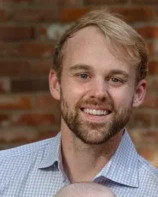 Dr. Jeffrey Kerst, DDS, smiling, in a blue checked shirt.