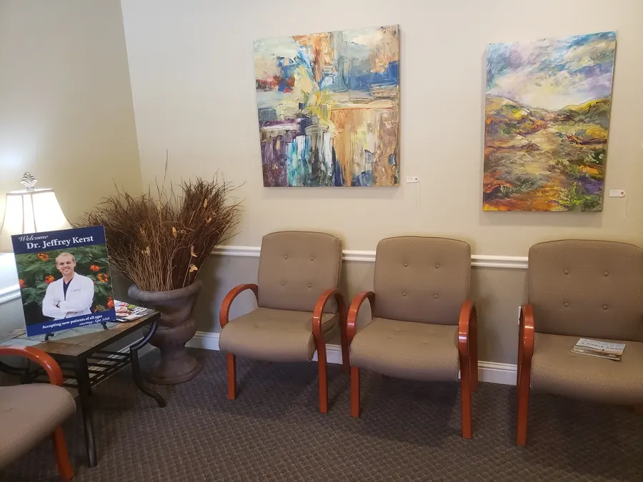 Waiting-room chairs beneath two colorful paintings.